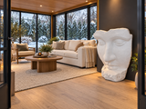 Sculpture de visage Atoll blanche à l’intérieur d’un solarium avec vue sur un jardin enneigé