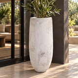 Vase Atoll Azura en béton sur une terrasse, avec végétal de mise en scène